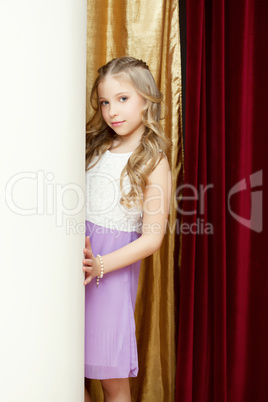 Cute curly girl posing on curtain backdrop