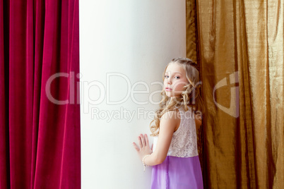 Cute blond little girl posing looking at camera