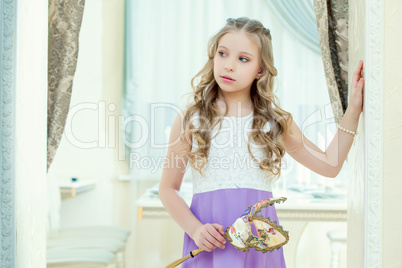 Little blue-eyed model posing with masquerade mask