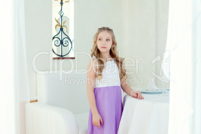 Image of serious cute little girl posing at table