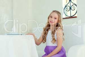 Image of adorable smiling girl posing at table
