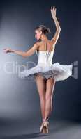 Rear view of graceful young ballerina dancing