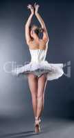 Graceful slim ballerina dancing back to camera