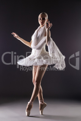 Adorable contemporary ballerina dancing in studio