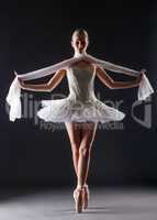 Graceful ballerina dancing looking at camera