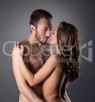 Passionate nude lovers embracing in studio