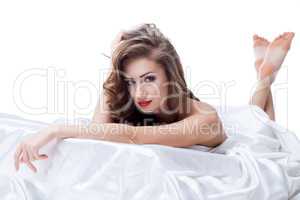 Beautiful nude model lying on silk sheets
