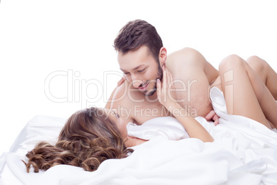 Smiling man looking at his mistress lying in bed