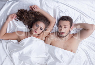 Image of young heterosexual couple posing in bed
