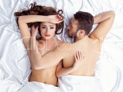 Image of weary young lovers lying on silk sheets