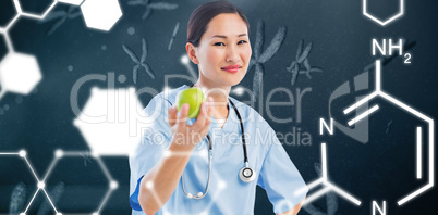 Composite image of smiling surgeon holding an apple with colleag