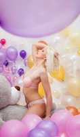 Seductive platinum blonde posing with balloons