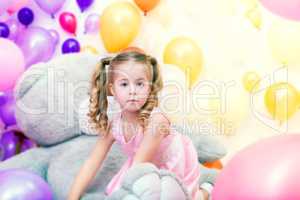 Funny little girl playing in studio with balloons