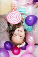 Top view of merry little girl posing with balloons