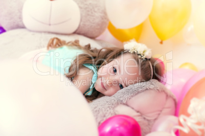Adorable little girl lying on plush bear