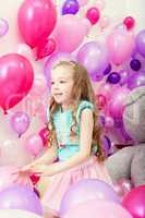 Image of cute little girl playing among balloons