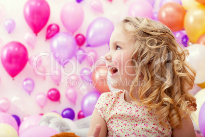 Adorable cheerful girl on balloons background