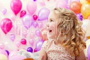 Adorable cheerful girl on balloons background