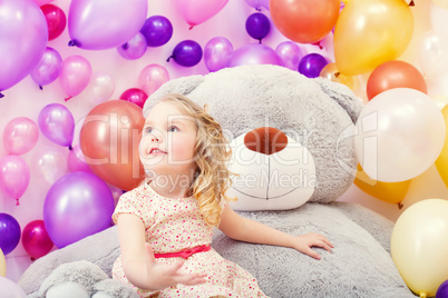 Funny little girl posing with big teddy bear