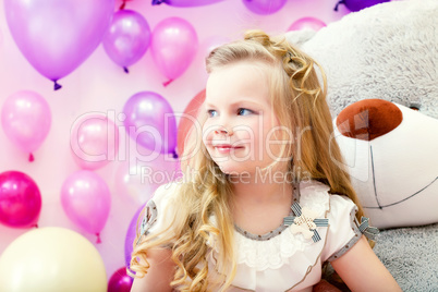 Smiling pretty blonde girl posing in playroom