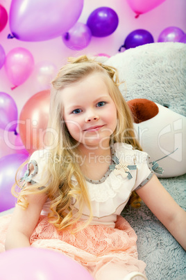 Smiling little blonde posing with big toy