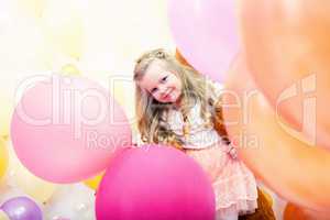 Merry curly girl posing with colorful balloons