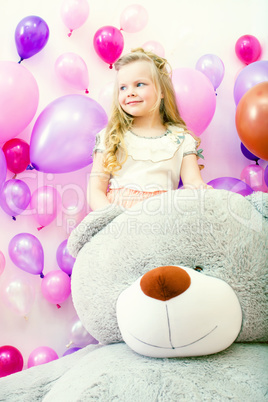 Smiling little girl posing with plush bear
