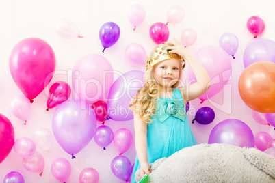 Image of comely little girl tries on toy crown