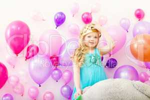 Image of comely little girl tries on toy crown