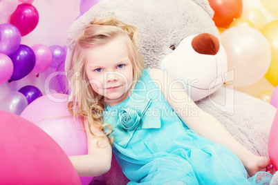 Serious blue-eyed little girl posing at camera