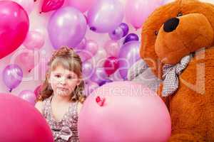 Beautiful curly girl posing among pink balloons