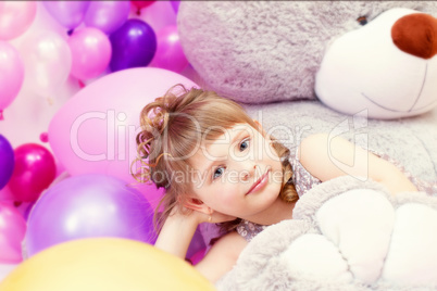 Shot of gray-eyed little girl lying on teddy bear