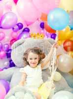 Cheerful girl posing holding bunch of balloons