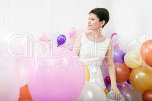 Elegant woman posing among colorful balloons