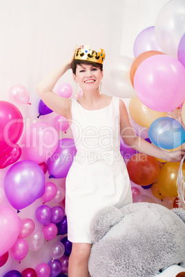 Cheerful adult woman tries on toy crown
