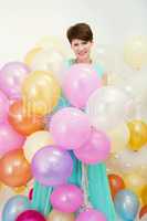 Pretty woman holds big bunch of colorful balloons