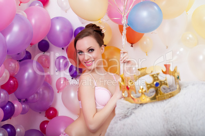 Smiling young woman posing with bunch of balloons