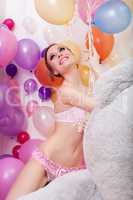 Happy slim girl posing with bunch of balloons