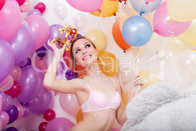 Image of happy young woman tries on toy crown