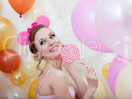Image of smiling comely girl posing with lollipop