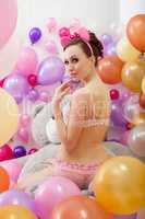 Playful slim woman posing in studio with balloons
