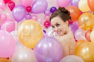Smiling young woman posing with balloons