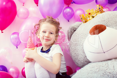 Smiling girl posing with ice cream in playroom