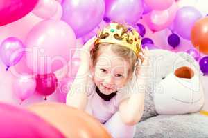 Portrait of funny little girl trying on crown