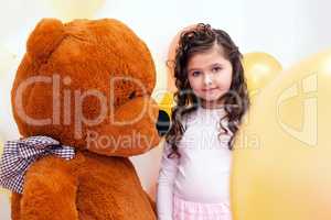 Cute little brunette posing with big teddy bear