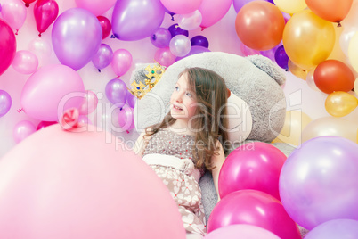 Smiling little lady posing lying on big teddy bear