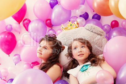 Dreamy sisters posing lying on big teddy bear