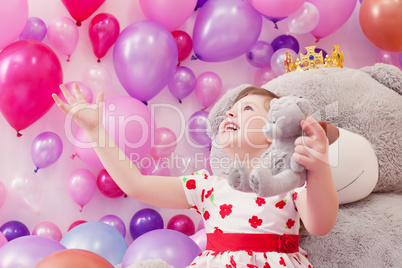 Joyful little girl playing with teddy bears