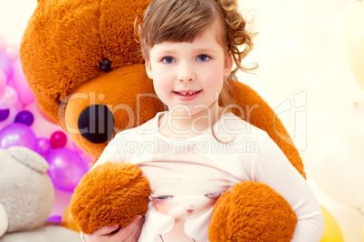 Nice little girl posing in arms of big teddy bear