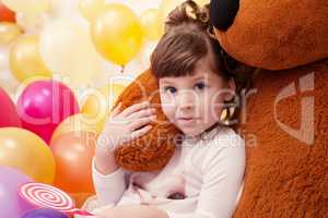 Portrait of lovely little girl hugging teddy bear